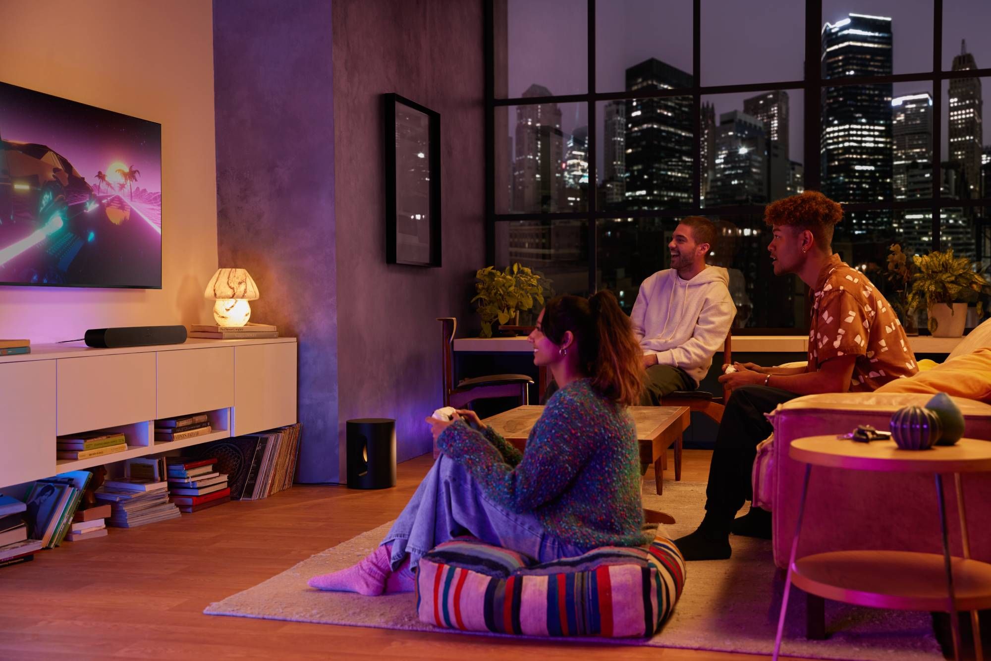 People in a living room watching TV with sonos soundbar